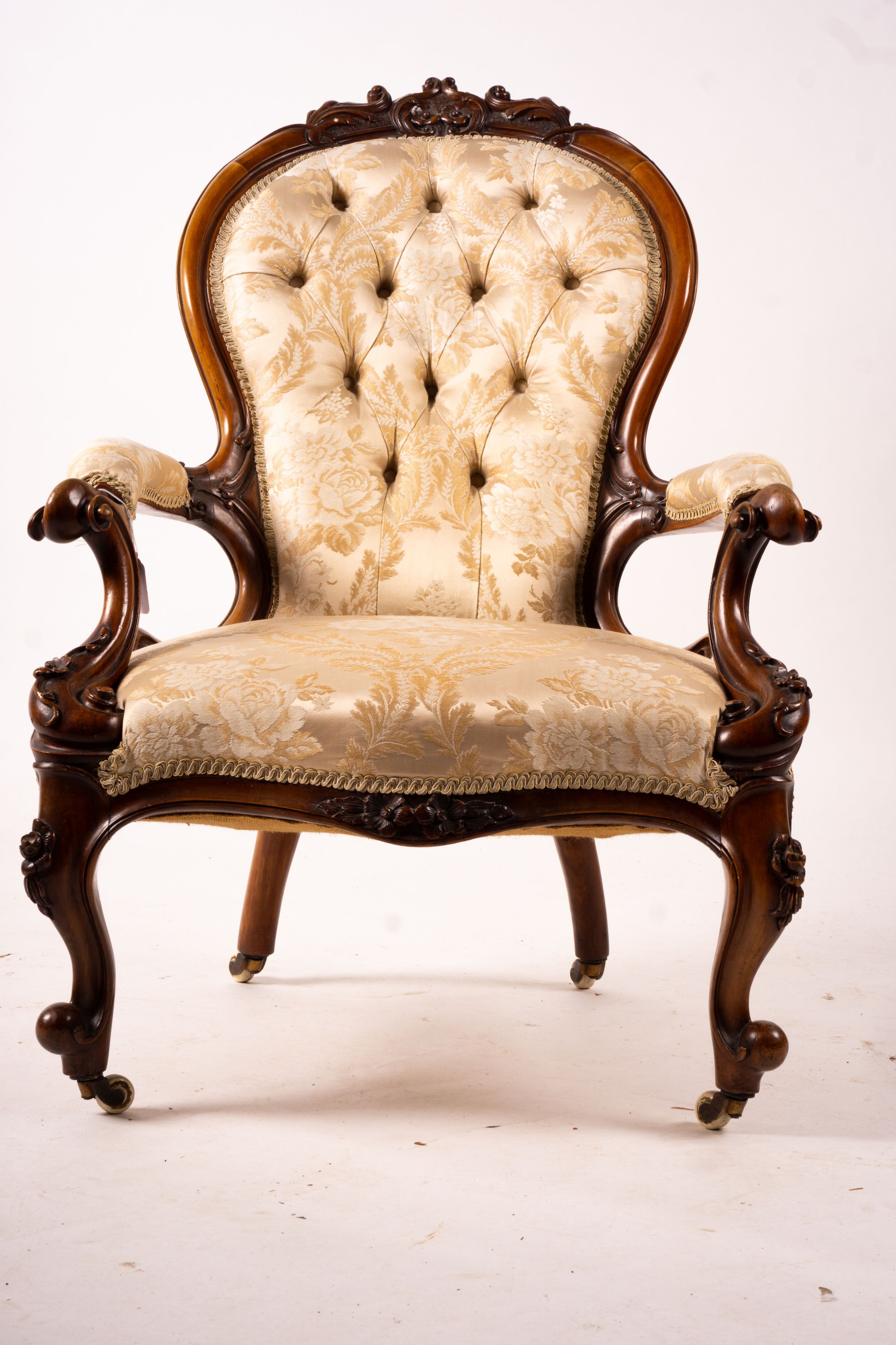 A late Victorian carved walnut three piece salon suite, comprising chaise longue, open armchair and nursing chair